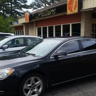 a black car parked in front of a restaurant