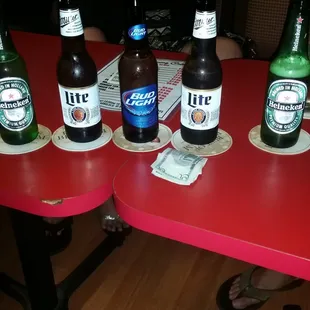 a row of beer bottles on a red table