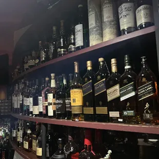 a shelf full of liquor bottles