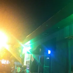 a group of people standing outside of a building at night