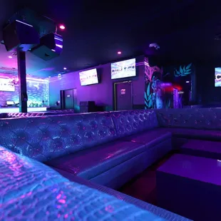 the interior of a club with purple lighting
