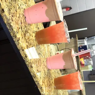a row of smoothie cups on a counter