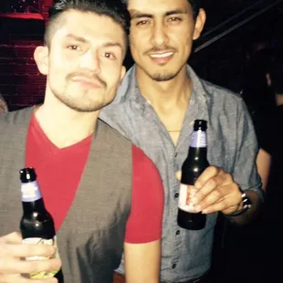 two men holding beer bottles