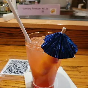 a cocktail with a blue umbrella