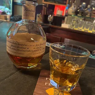 a glass of whiskey and a decanter