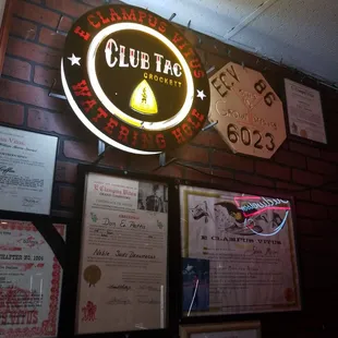 a neon sign above a brick wall