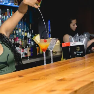 a woman pouring a drink at a bar