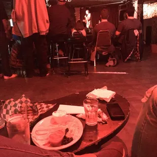 people sitting at a bar with food and drinks