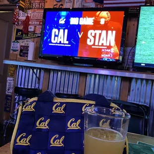 a glass of orange juice and a television in the background