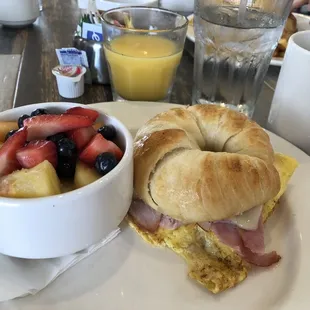 a croissant sandwich and fruit salad