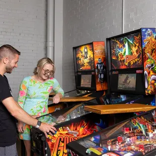  a man and a woman playing pinball