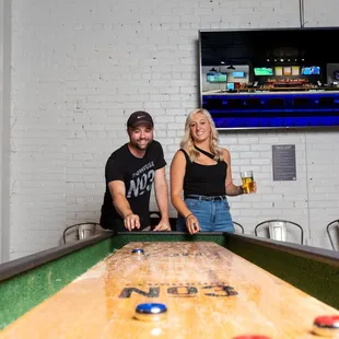  a man and a woman playing a game of air hockey