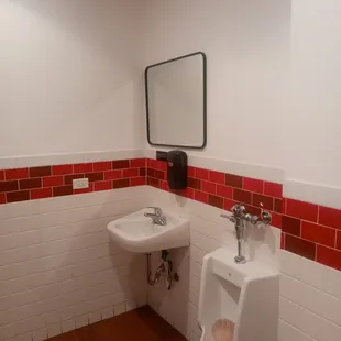 a bathroom with a urinal and sink