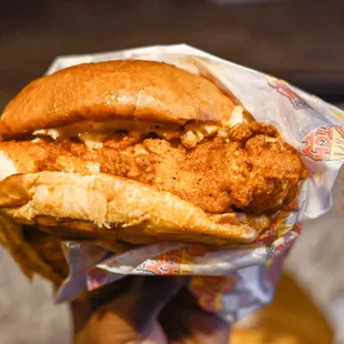 a hand holding a chicken sandwich