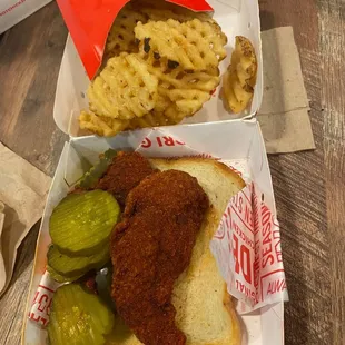 Two chicken strips with waffle fries