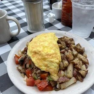 Omelette with sausage, peppers, tomatoes, and mushrooms.
