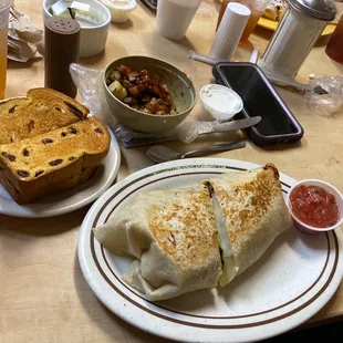 Philly breakfast burrito with a side of cinnamon raisin toast and fried potatoes