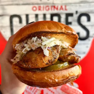 a hand holding a chicken sandwich