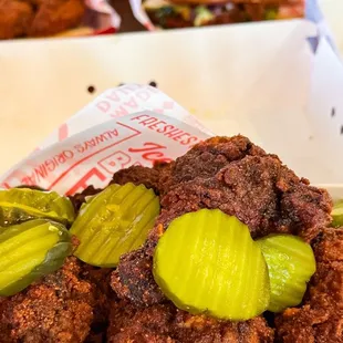 a tray of fried chicken with pickles