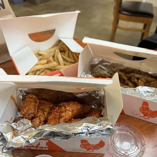 two boxes of chicken wings and french fries