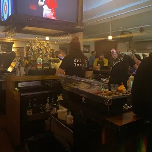 people at the bar watching television