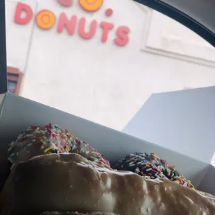 a box of doughnuts in front of a donut shop