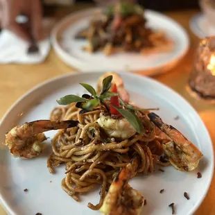 a plate of pasta with shrimp and vegetables