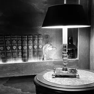 a table with a lamp and books