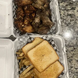 two trays of food including a sandwich and french fries