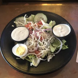 a plate of salad with dressings on it