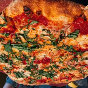 a pizza with pepperoni, basil, and cheese