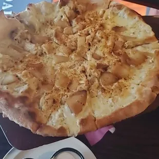 a hand holding a large pizza