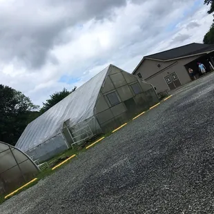 two greenhouses on the side of a road