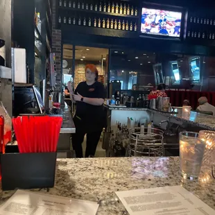 a woman standing at a counter in a restaurant
