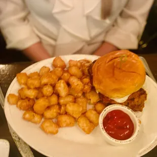 a burger and tater tots on a plate