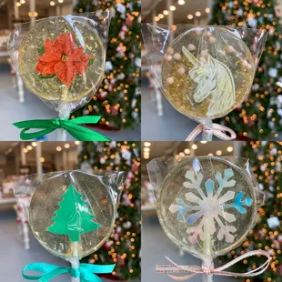 four lollipops in front of a christmas tree
