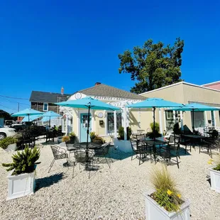 the outside of a restaurant with tables and umbrellas