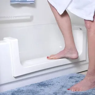 a woman stepping on a bathtub