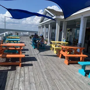 picnic tables and umbrellas on a wooden deck