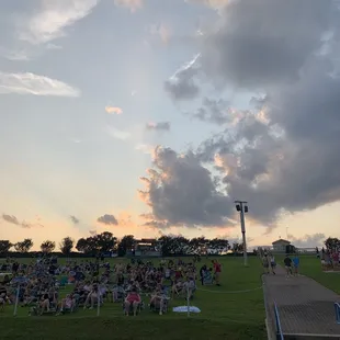 a crowd of people sitting on the grass