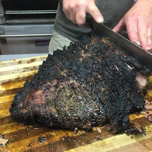 a man slicing a large piece of meat