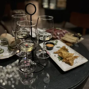 a table with wine glasses and plates of food