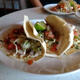 three tacos on a white plate
