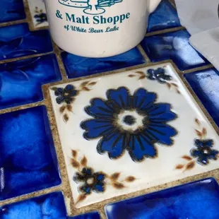 a coffee cup on a blue and white tile table