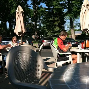 people sitting at tables with umbrellas