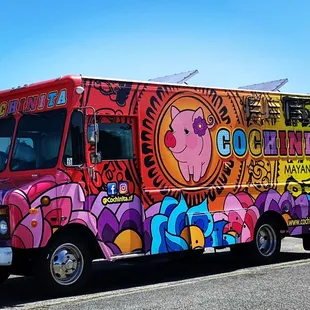 a colorful food truck parked on the side of the road