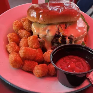 a burger and tater tots on a plate