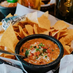 a bowl of salsa with tortillas and beer