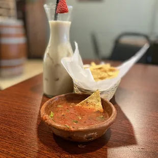 a bowl of salsa and a glass of milk
