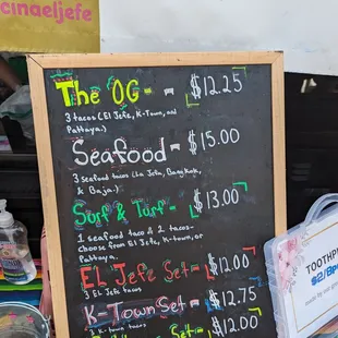 a chalkboard with prices of food